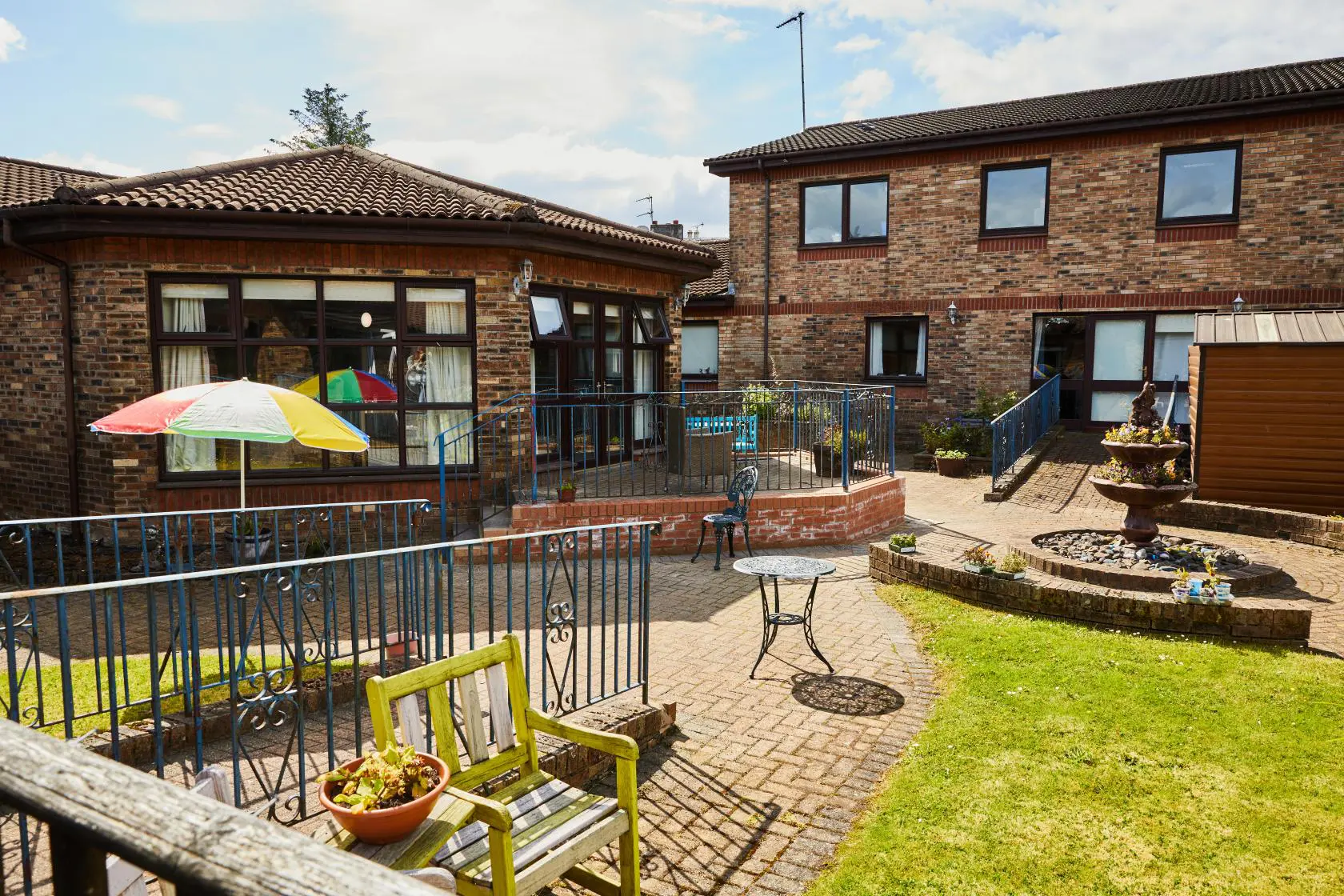 View of the patio, planted water feature and round lounge room at Spiers Care Home