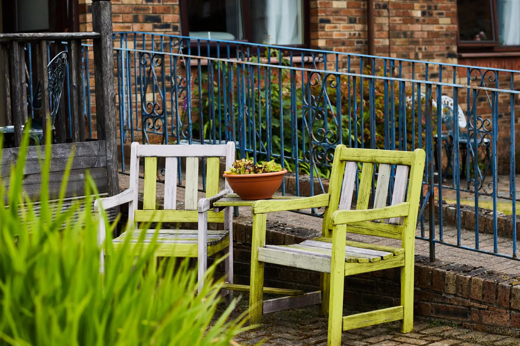 Yellow, wooden garden seats with table in between at Spiers Care Home