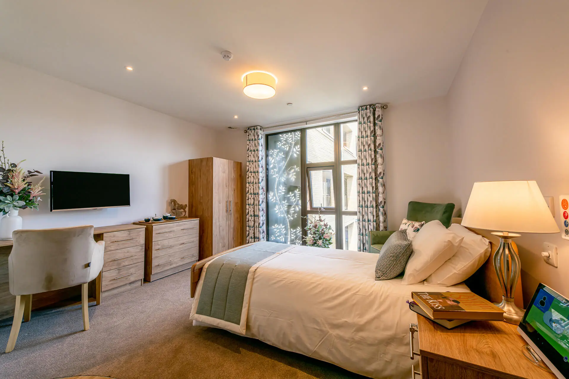 A light and airy bedroom at Surbitonian Gardens with white sheets and a duck egg blue throw on the bed.
