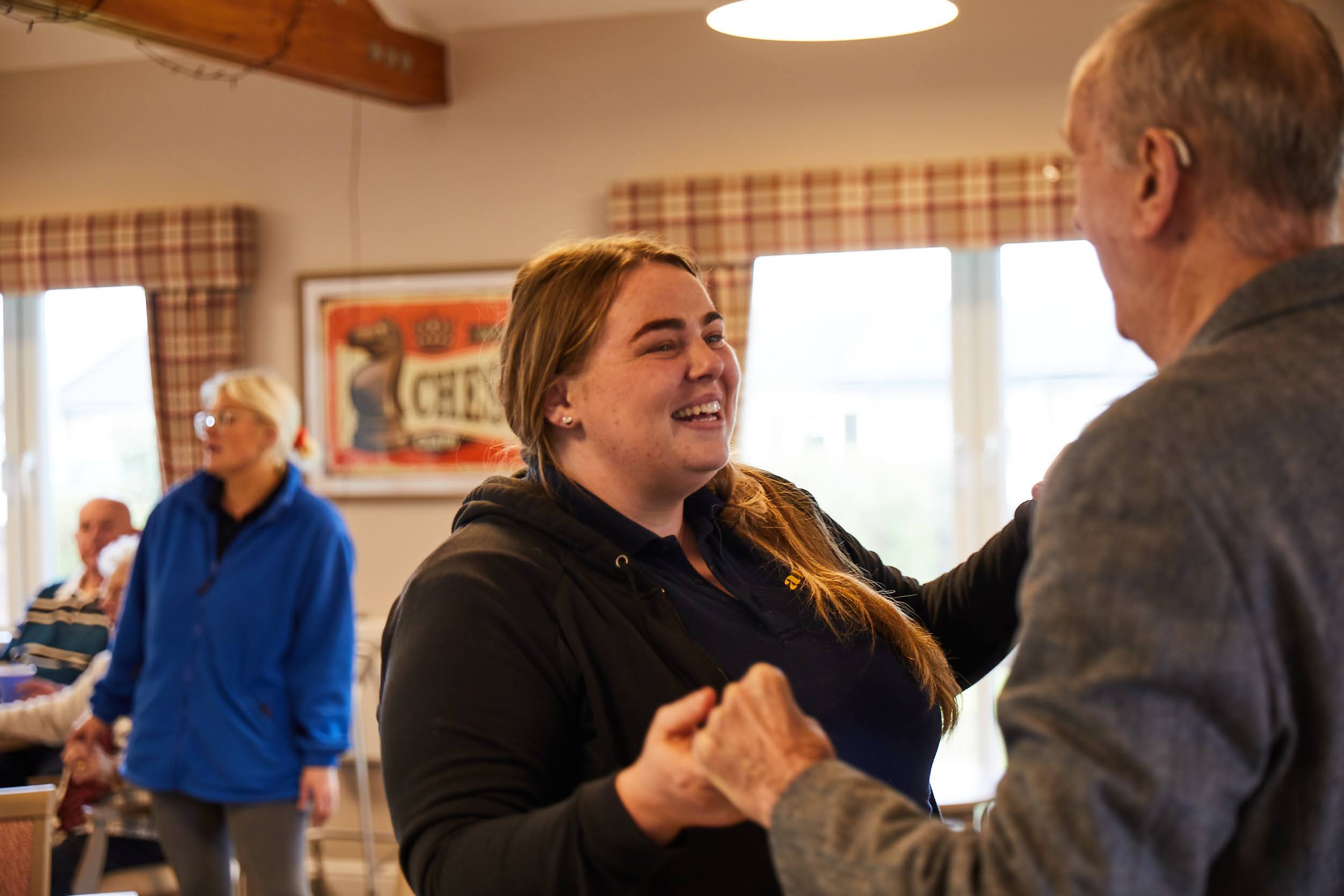 Staff member and tall guest dancing at Brampton Lodge Day Centre