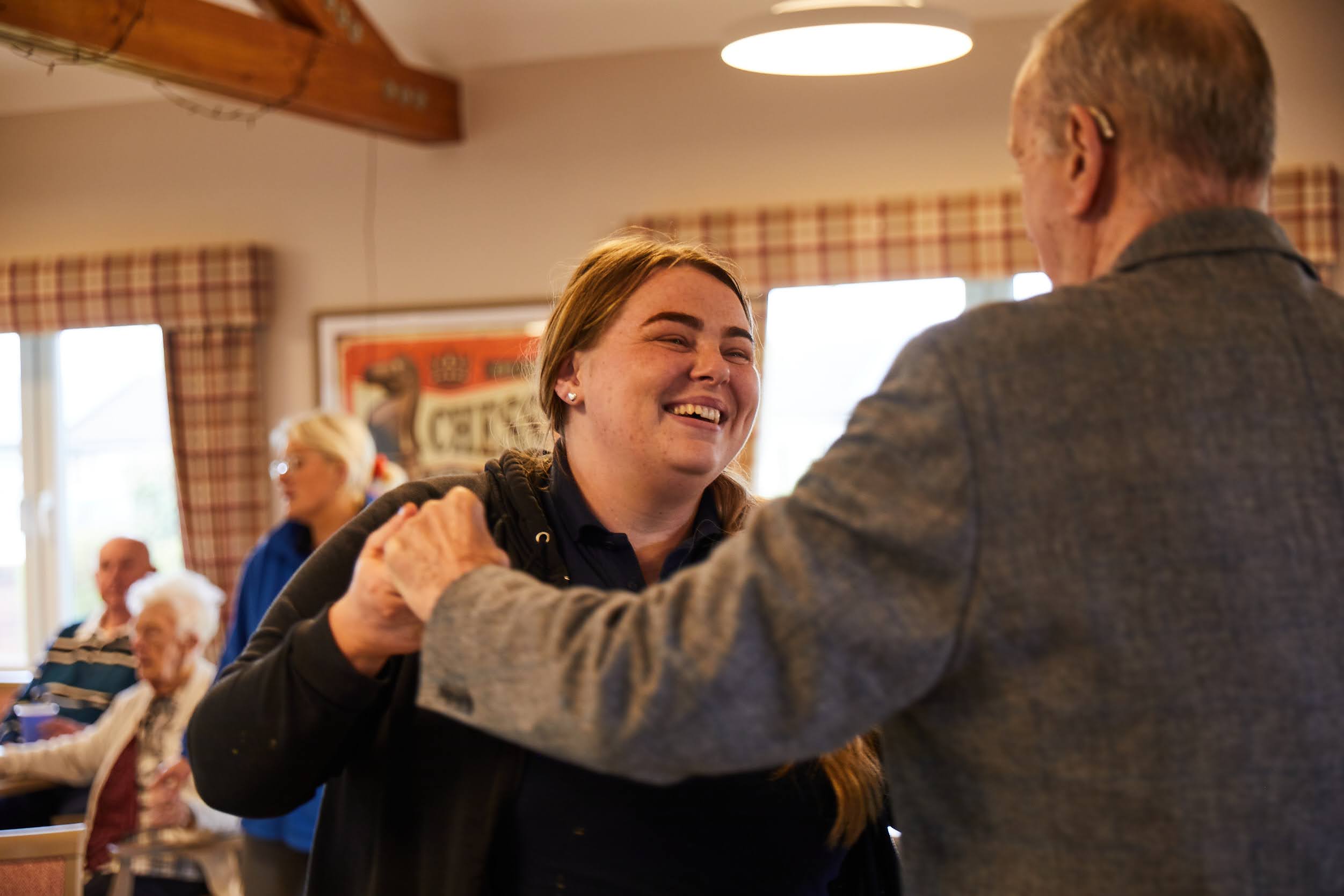 A lady carer dancing with a gentlemen during a dancing activity at Brampton Lodge Day Centre