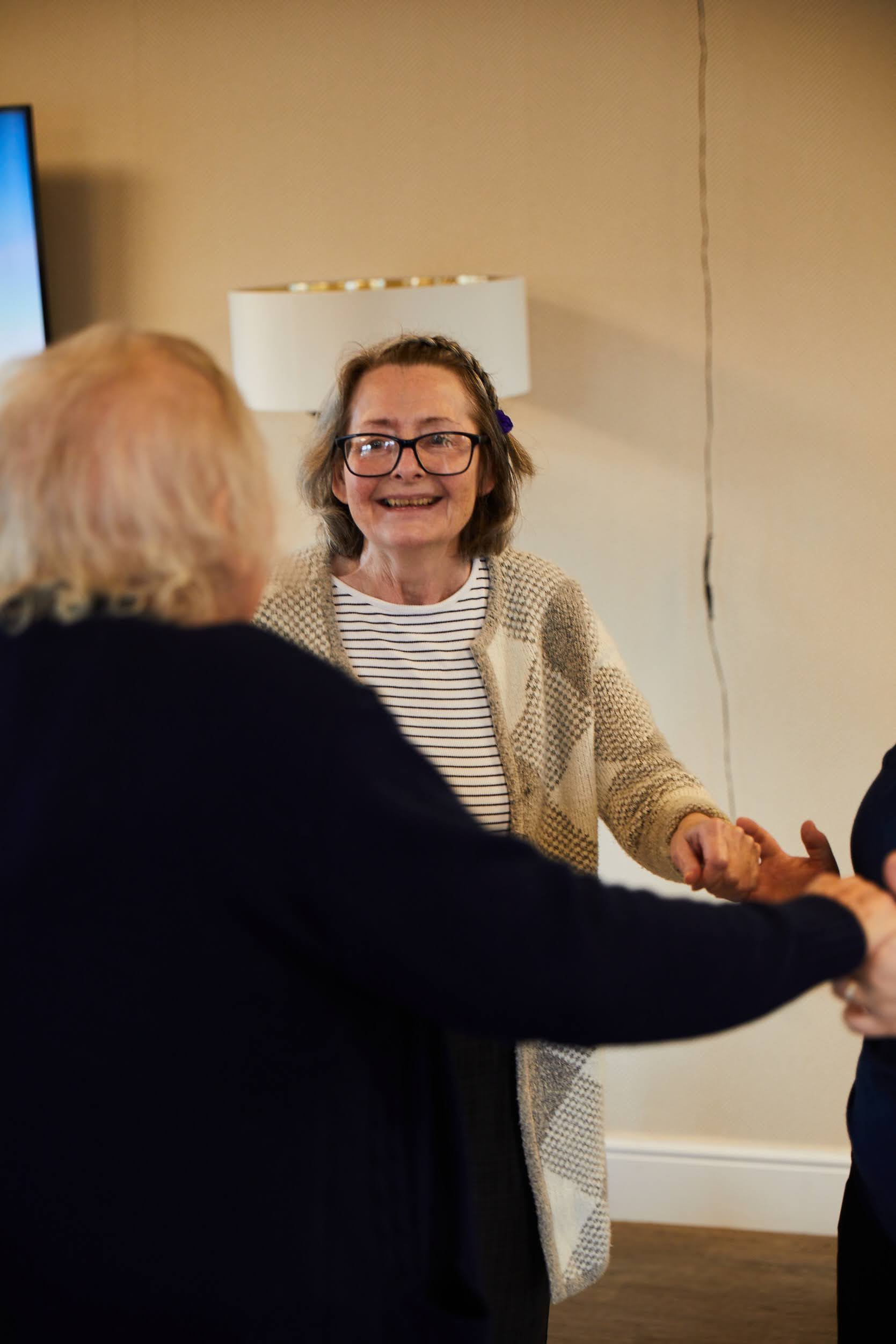 A guest smiling while dancing at Brampton Lodge Day Centre