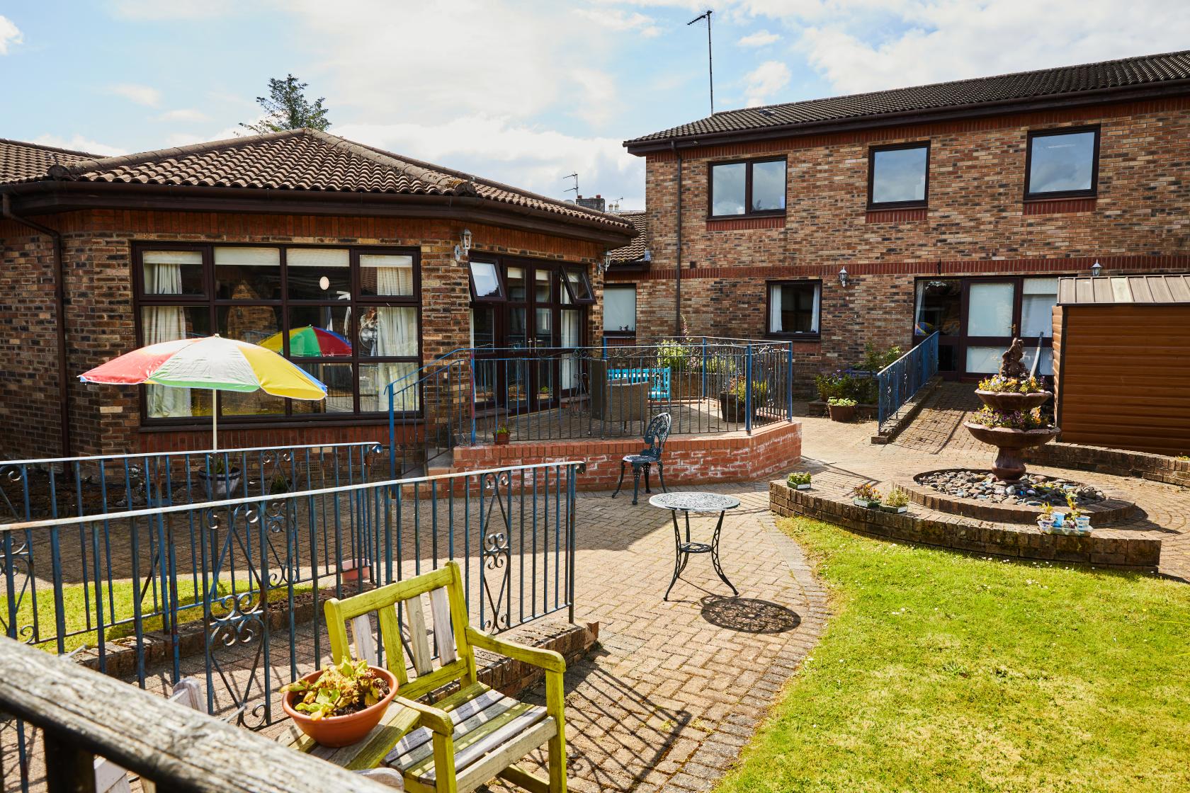 View of the patio, planted water feature and round lounge room at Spiers Care Home