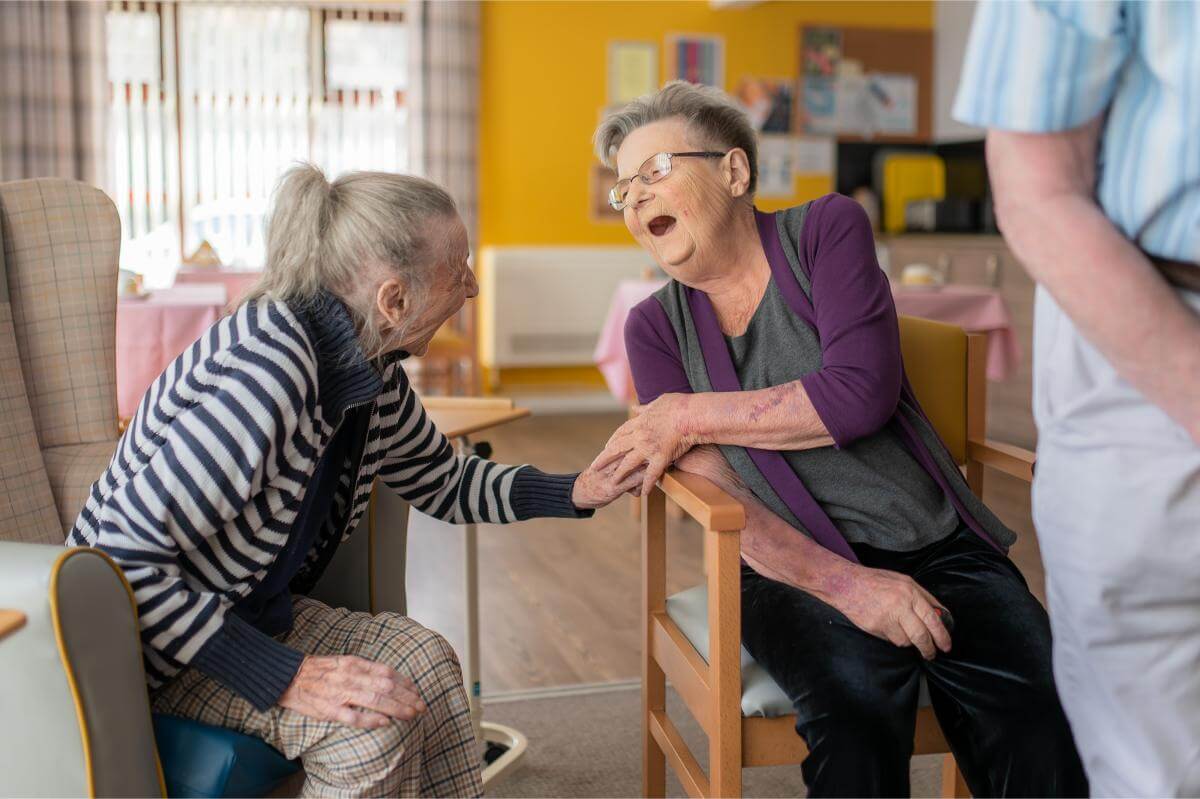 Two residents laughing sitting in the Spiers lounge