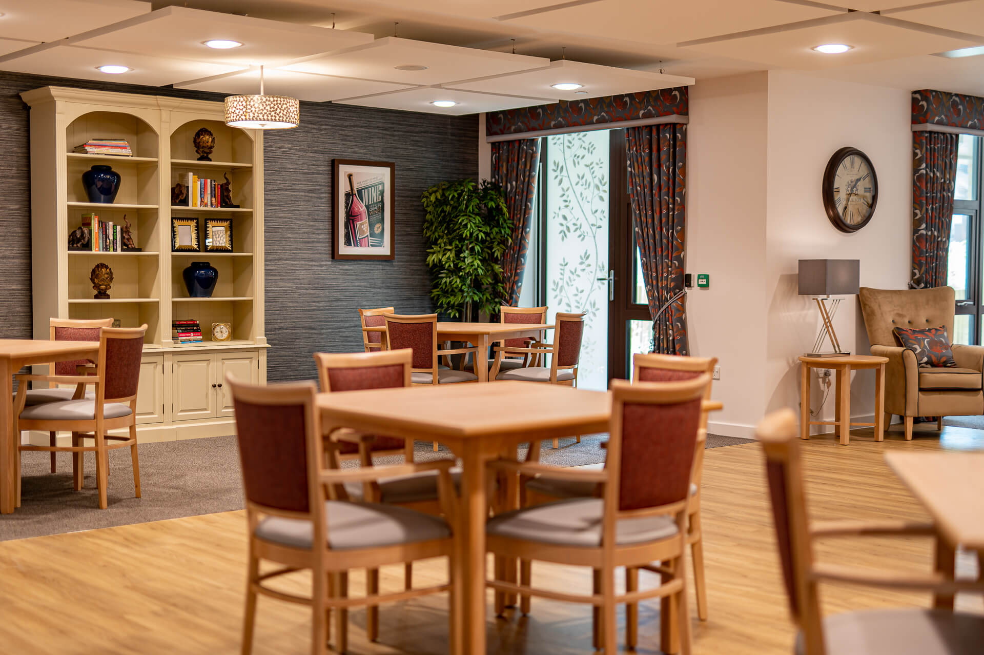 Sets of 4 wooden chairs and tables in a dining area at Surbitonian Gardens Care Home.