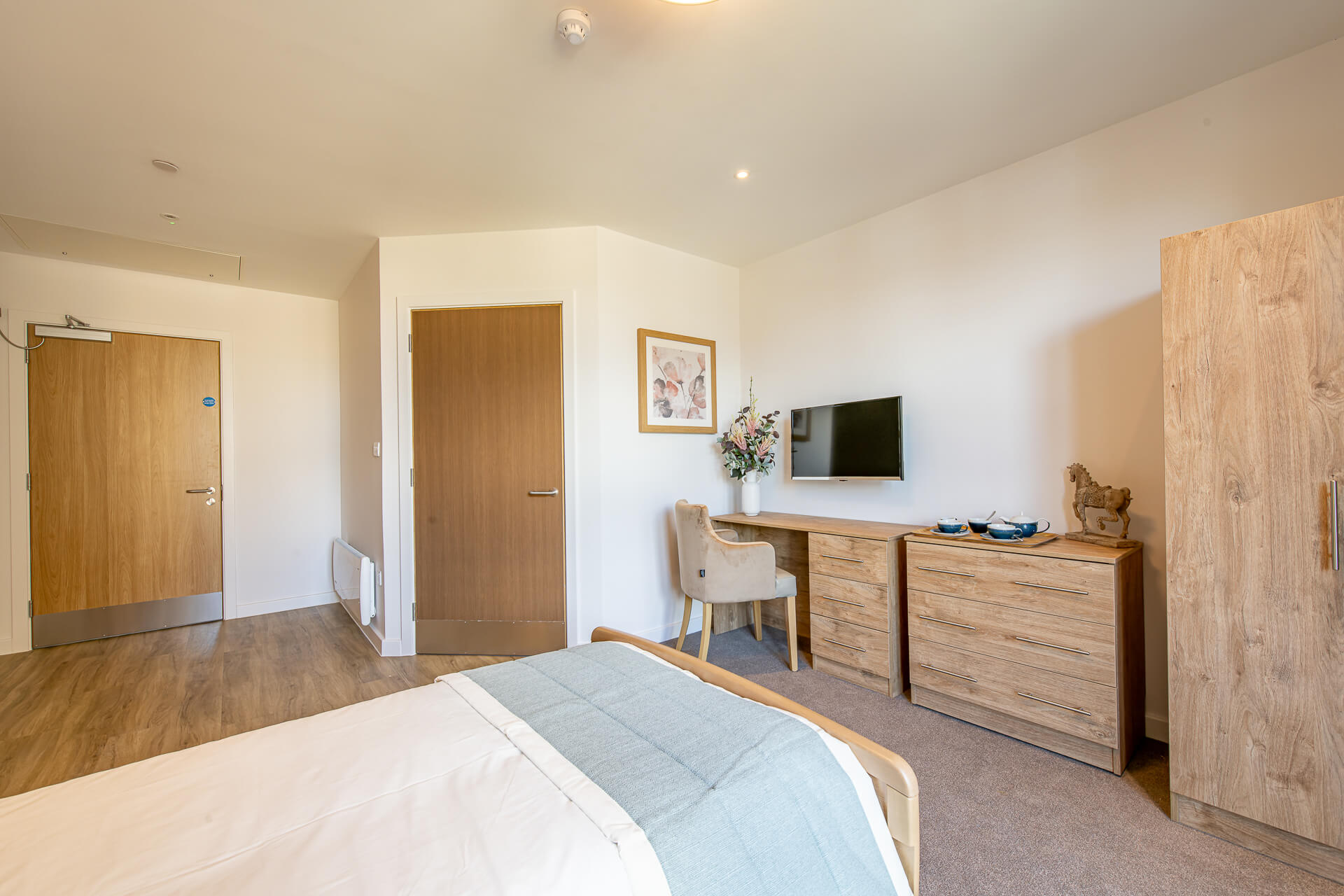 An view of a bedroom and ensuite access from the window at Surbitonian Gardens Care Home in Surbiton.