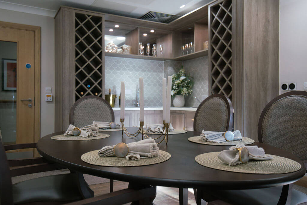Oval dining table laid with place settings and a 4 candle candelabra.