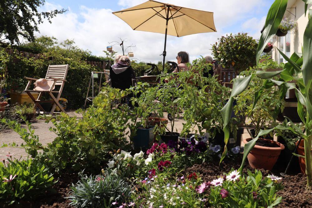 People sitting outside under parasol on a surrounded by